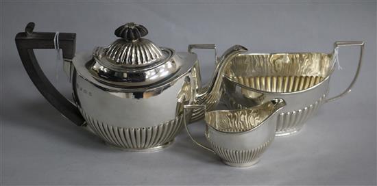 A matched three-piece silver batchelor tea service, of oval half-fluted form,